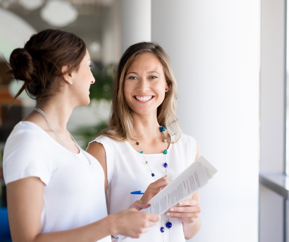 Smiling women in business conversation, professional consulting, Charlotte Wilding Consulting SEO.